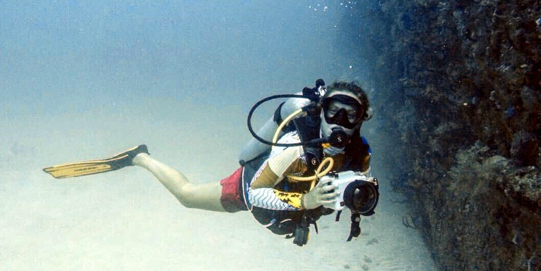  Un participante de GVI fotografía un naufragio submarino mientras registra inmersiones para sus cursos de buceo PADI.