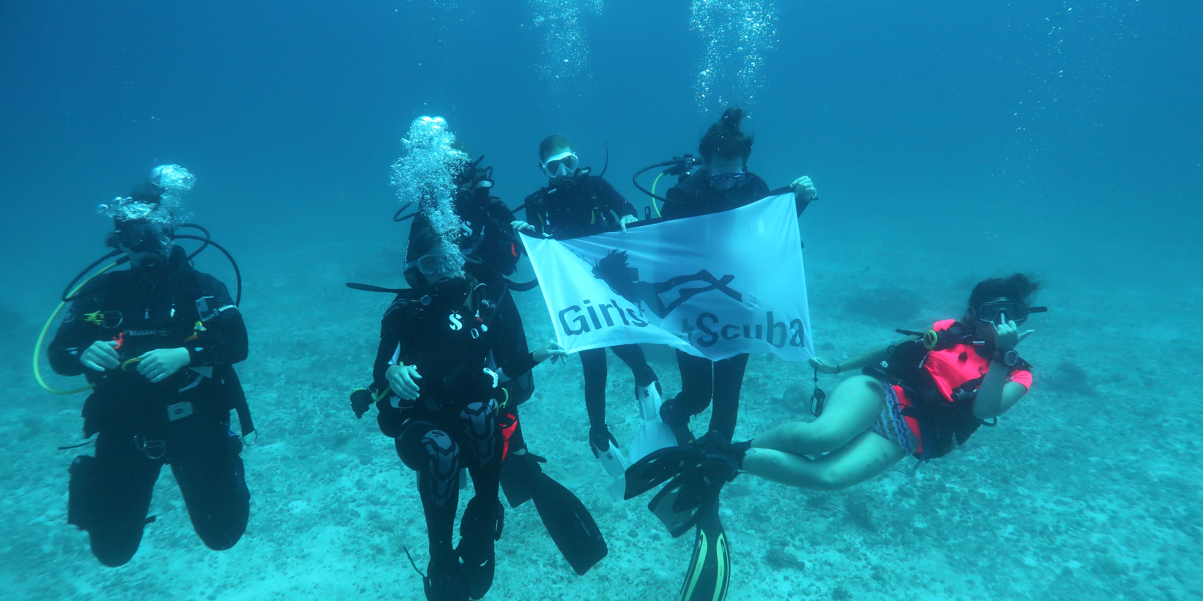 een team vrouwelijke duikers verkent de riffen rond Mahe terwijl ze werken aan hun PADI scuba Kwalificatie.